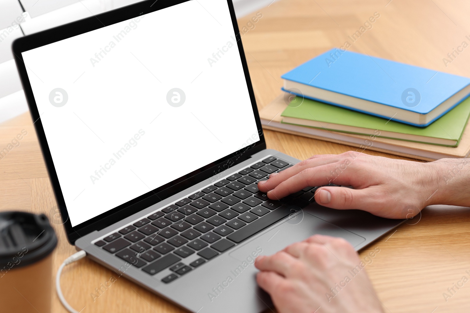 Photo of E-learning. Man using laptop during online lesson at table indoors, closeup