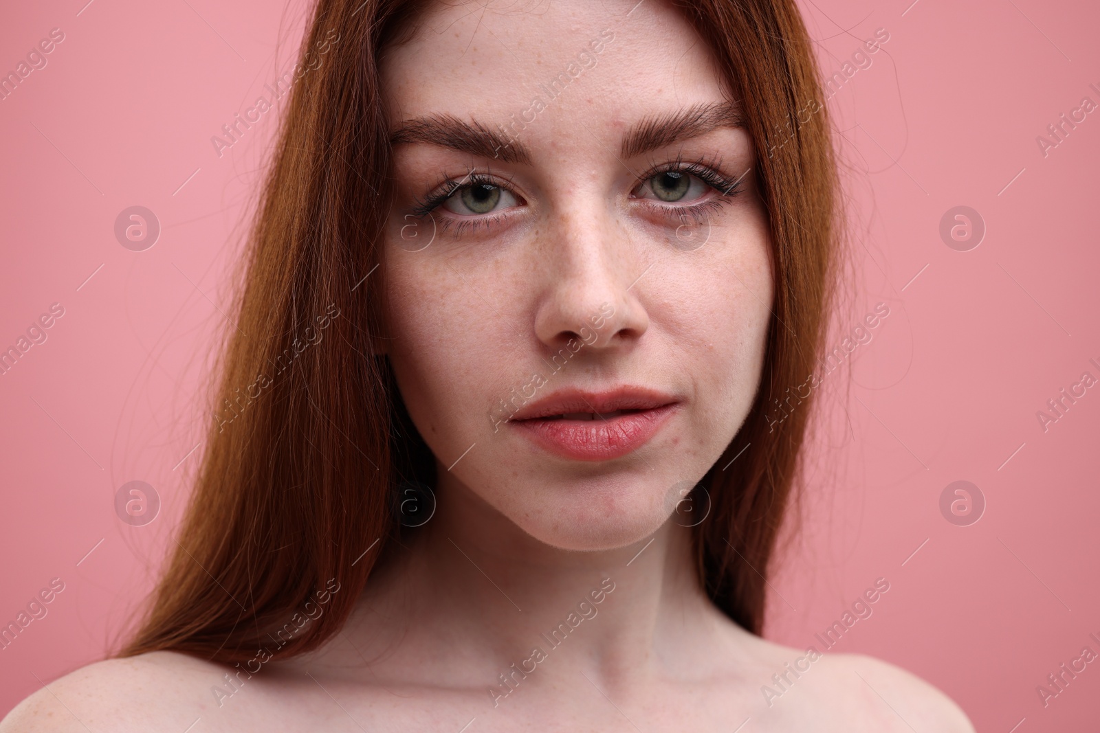 Photo of Portrait of beautiful woman with freckles on pink background, closeup