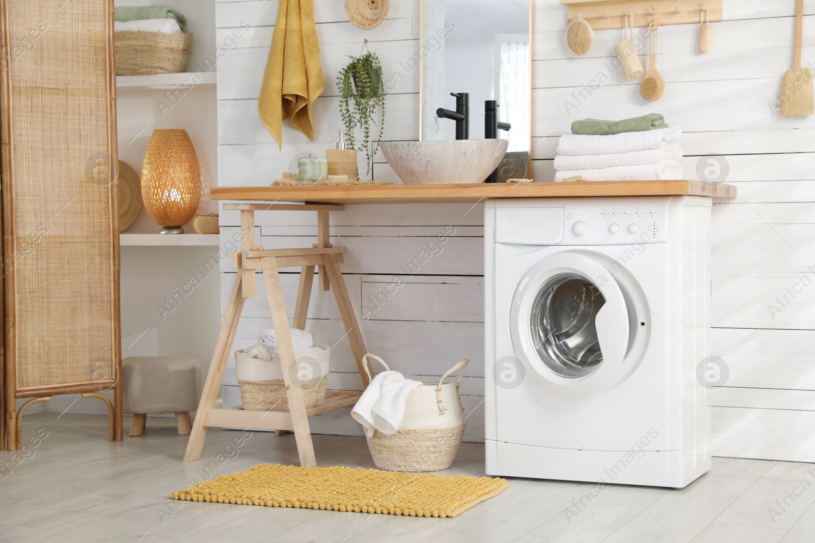 Photo of Stylish bathroom interior with modern washing machine