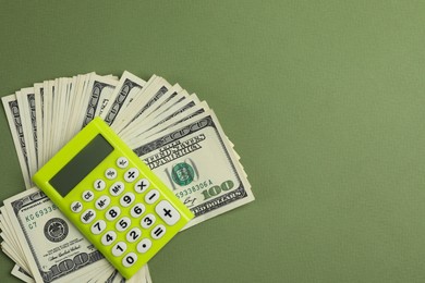 Photo of Money exchange. Dollar banknotes and calculator on green background, top view. Space for text