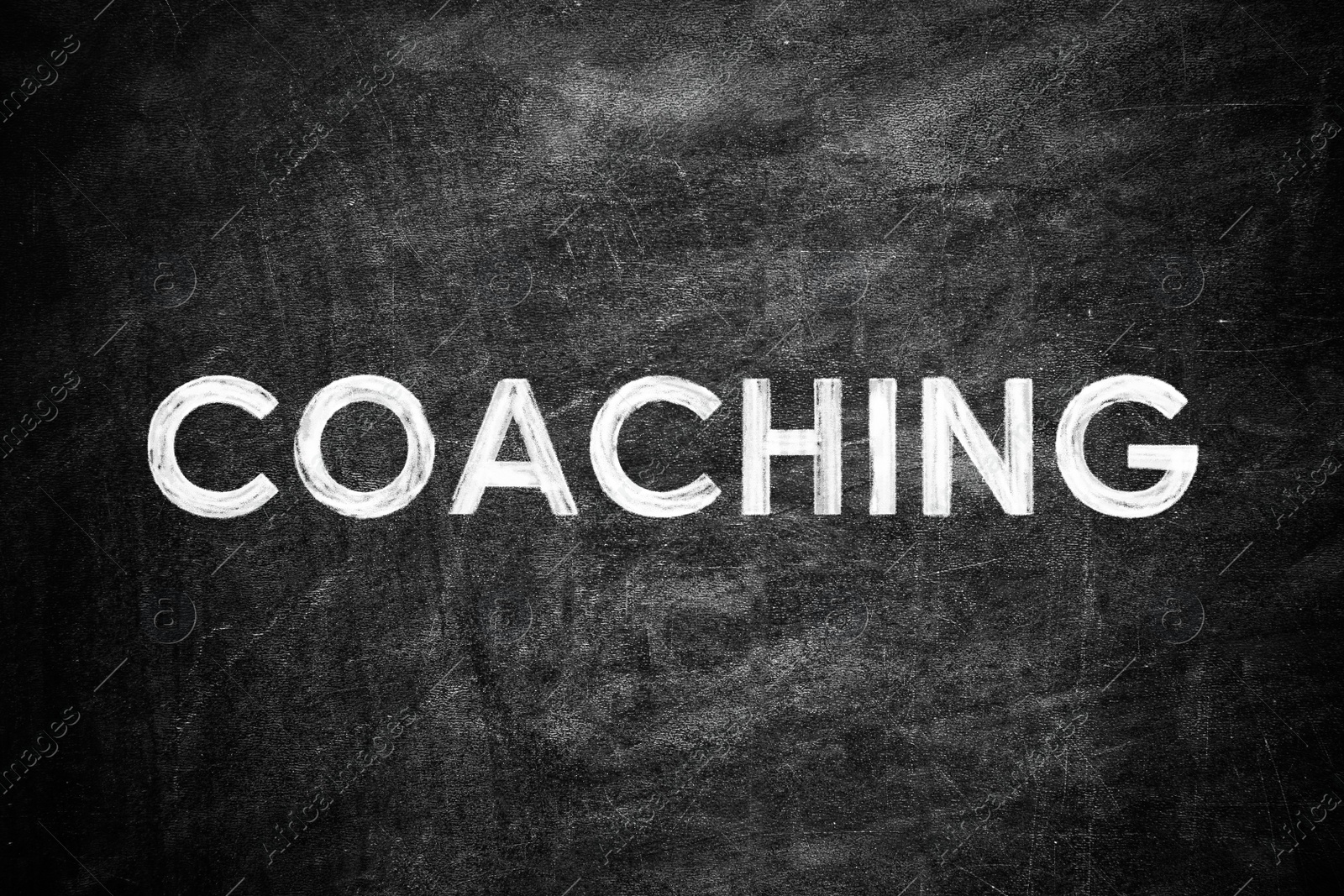 Image of Adult learning. Word COACHING written on black chalkboard