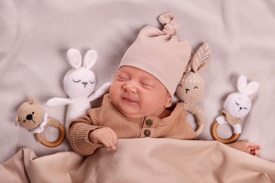 Cute newborn baby sleeping with toys in bed, top view