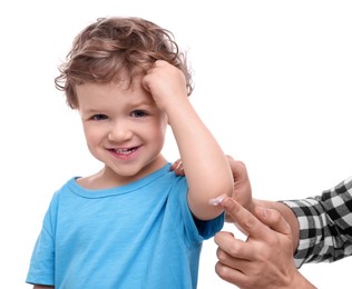 Photo of Father applying ointment onto his son`s elbow on white background