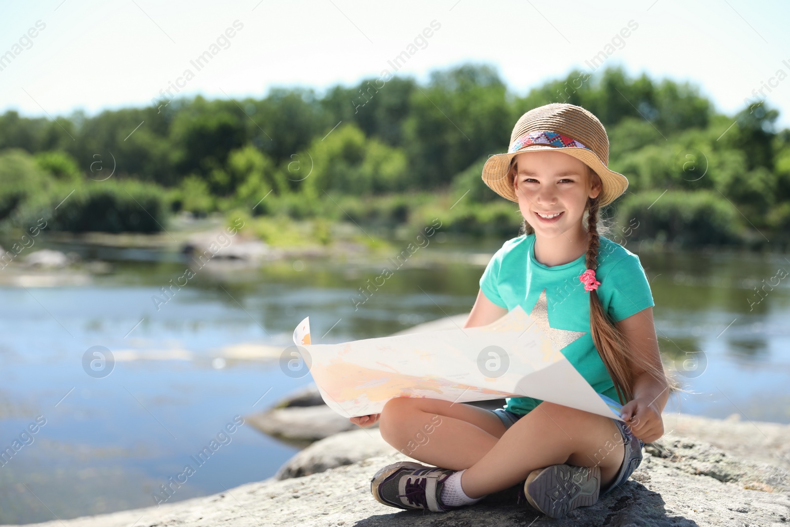 Photo of Little girl with map outdoors. Summer camp