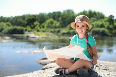 Little girl with map outdoors. Summer camp