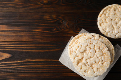 Photo of Stack of crunchy rice cakes on wooden table, flat lay. Space for text