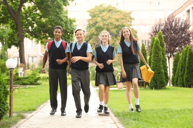 Photo of Teenage students in stylish school uniform outdoors