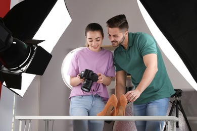 Photo of Professional photographers shooting stylish shoes in studio