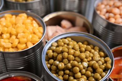 Photo of Open tin cans with conserved products, closeup