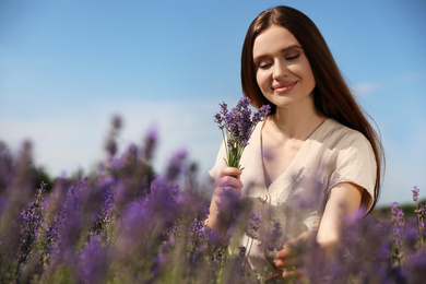 Young woman with lavender bouquet in field on summer day