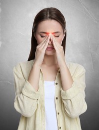 Young woman having headache on light grey background