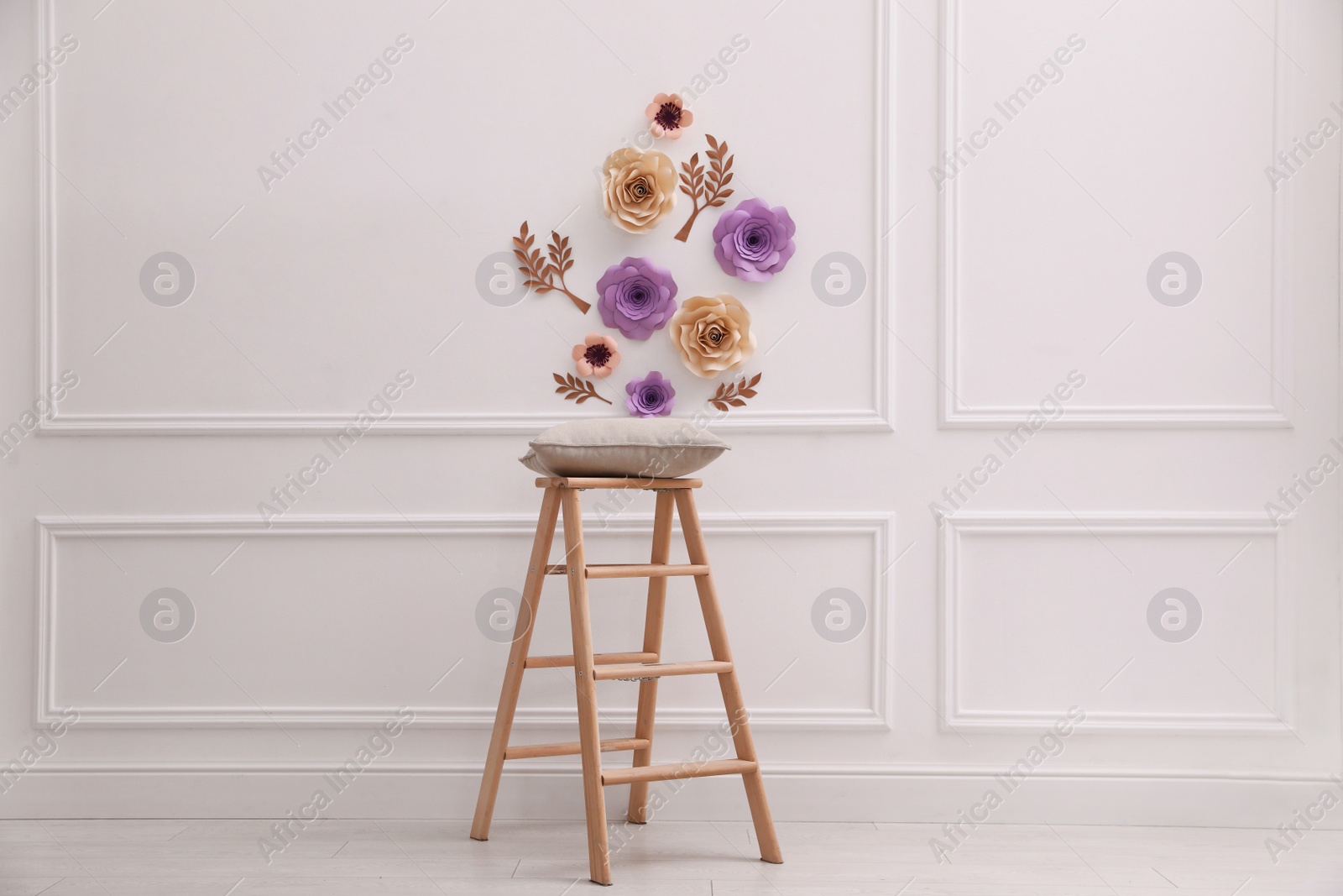 Photo of Stylish room interior with floral decor and wooden stand