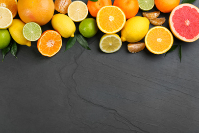 Flat lay composition with tangerines and different citrus fruits on black background. Space for text