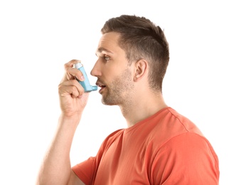 Photo of Young man with asthma using inhaler on white background