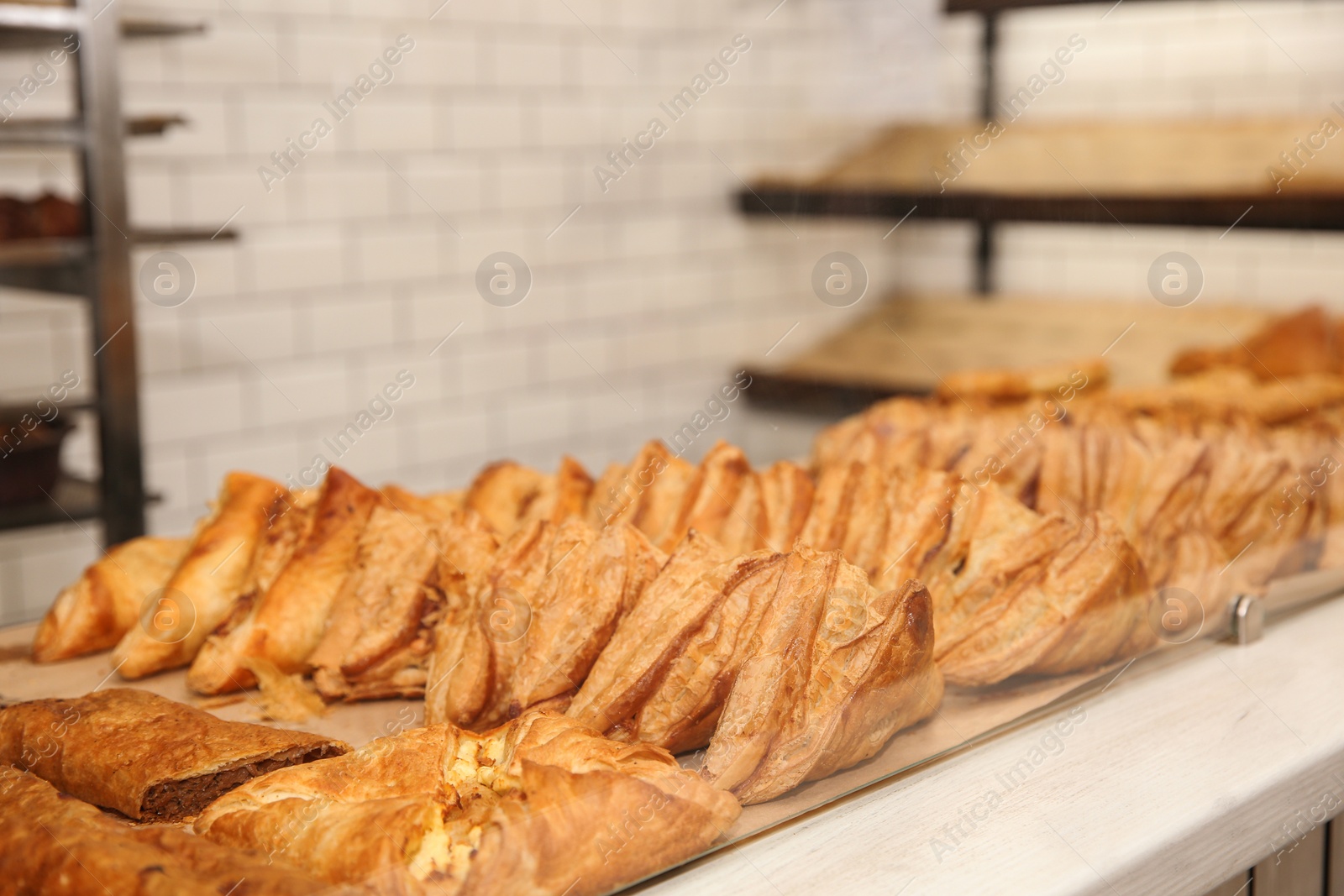 Photo of Fresh pastries on counter in bakery store. Space for text