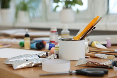 Photo of Many painting tools on wooden table indoors, closeup. Creative hobby