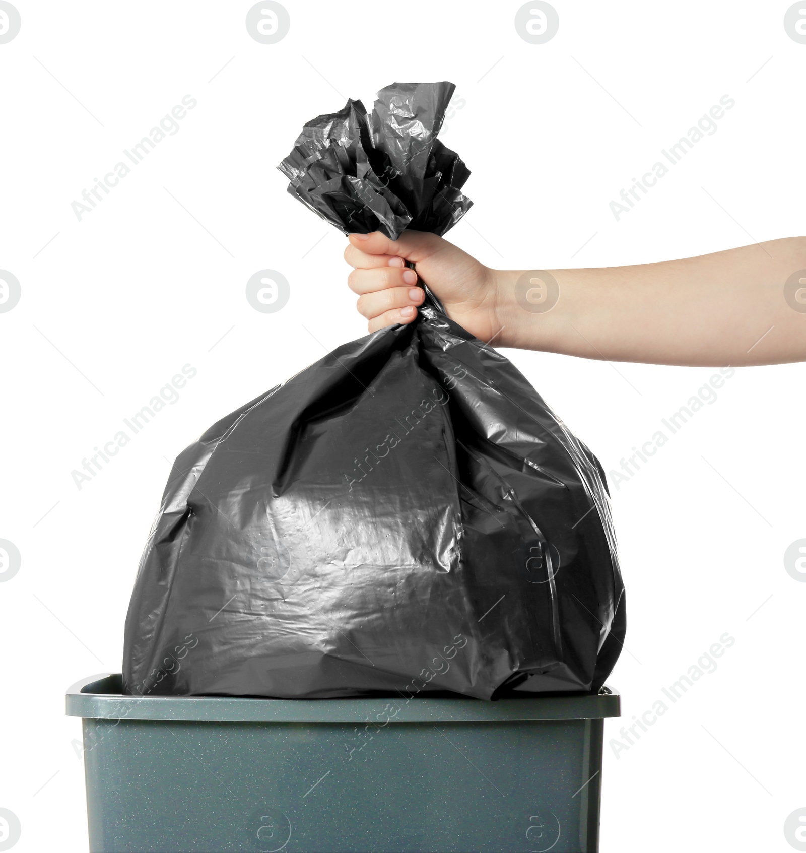 Photo of Woman holding trash bag full of garbage over bucket on white background, closeup