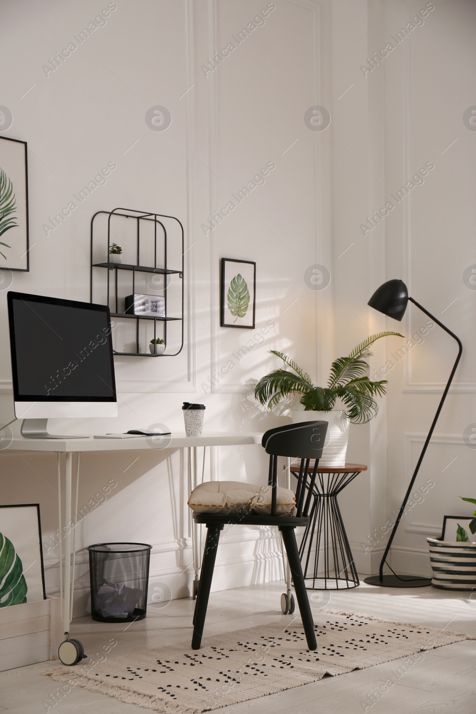 Photo of Comfortable workplace with modern computer and houseplants in room. Interior design