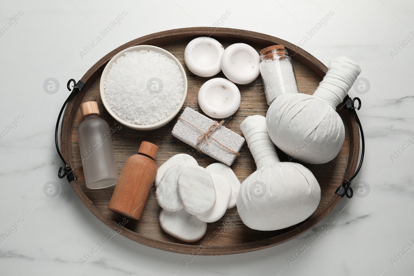 Photo of Composition with herbal massage bags and other spa products on light grey marble table, top view