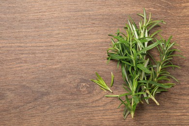 Fresh green rosemary on wooden table, top view. Space for text