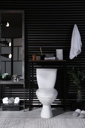 Stylish bathroom interior with toilet bowl and other essentials