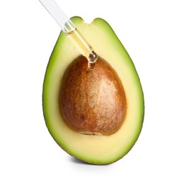Photo of Dripping essential oil onto cut avocado on white background
