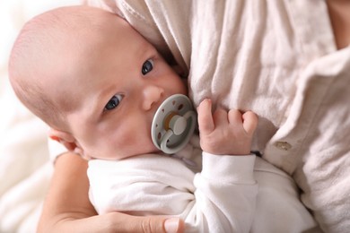 Photo of Mother hugging cute newborn baby on bed, closeup