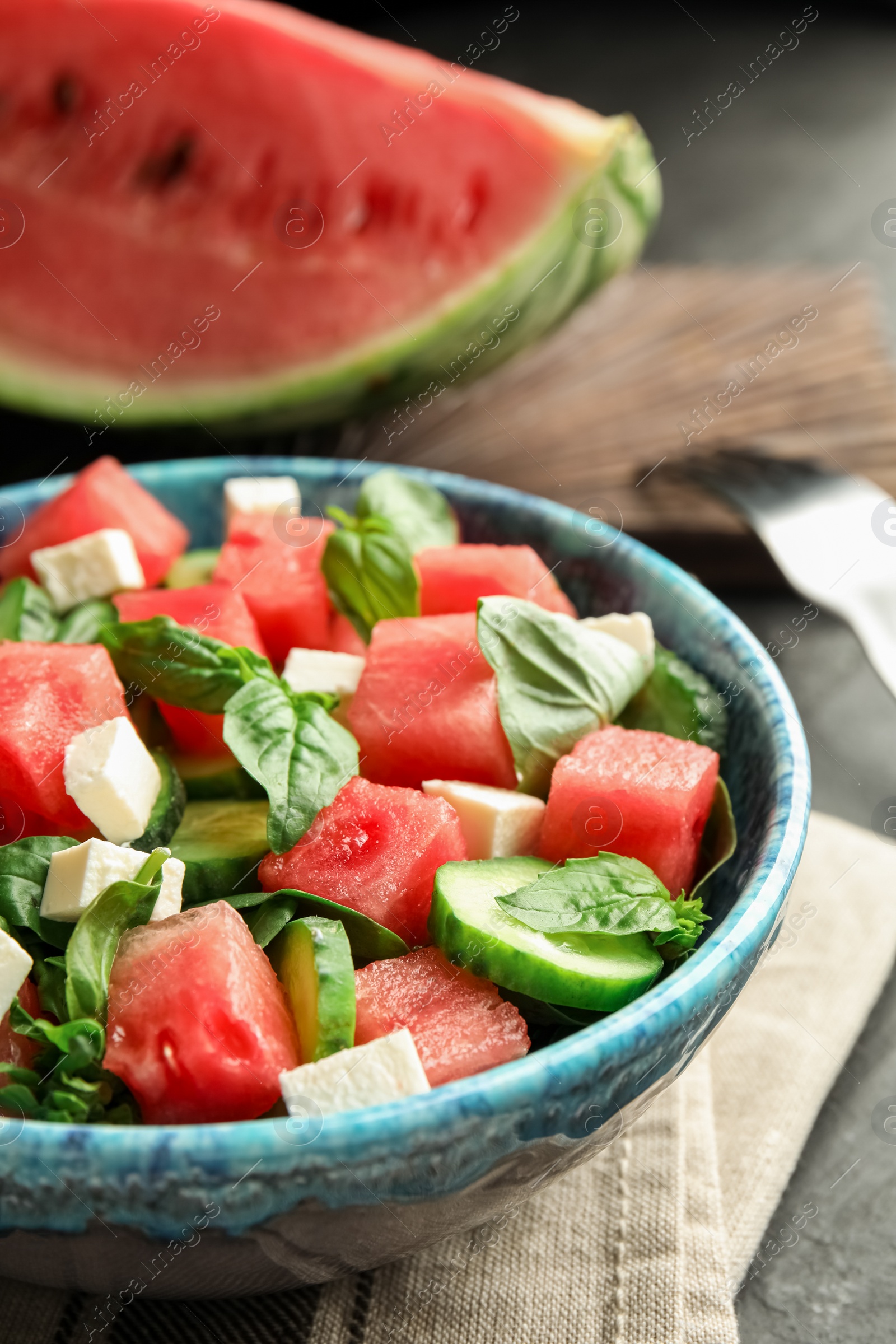 Photo of Delicious salad with watermelon served on black table, closeup