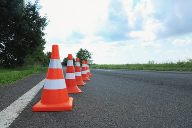Photo of Traffic cones on asphalt highway, space for text. Road repair