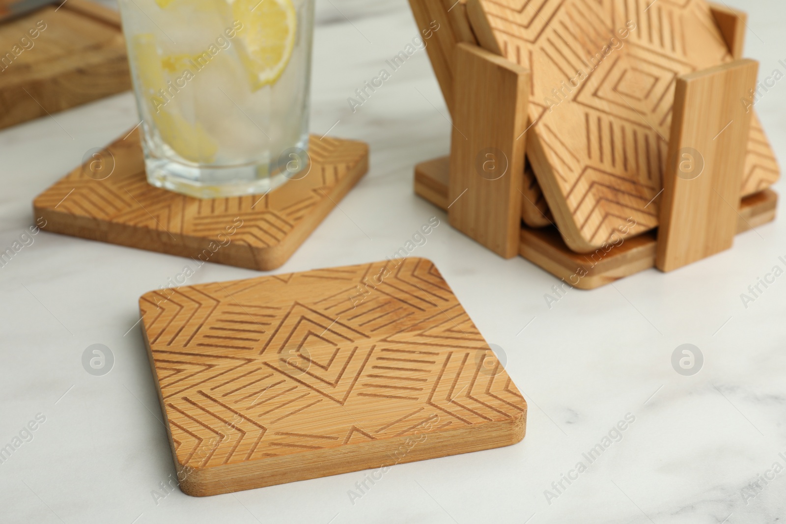 Photo of Stylish wooden cup coasters on white table