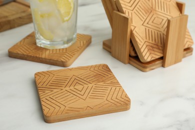 Stylish wooden cup coasters on white table