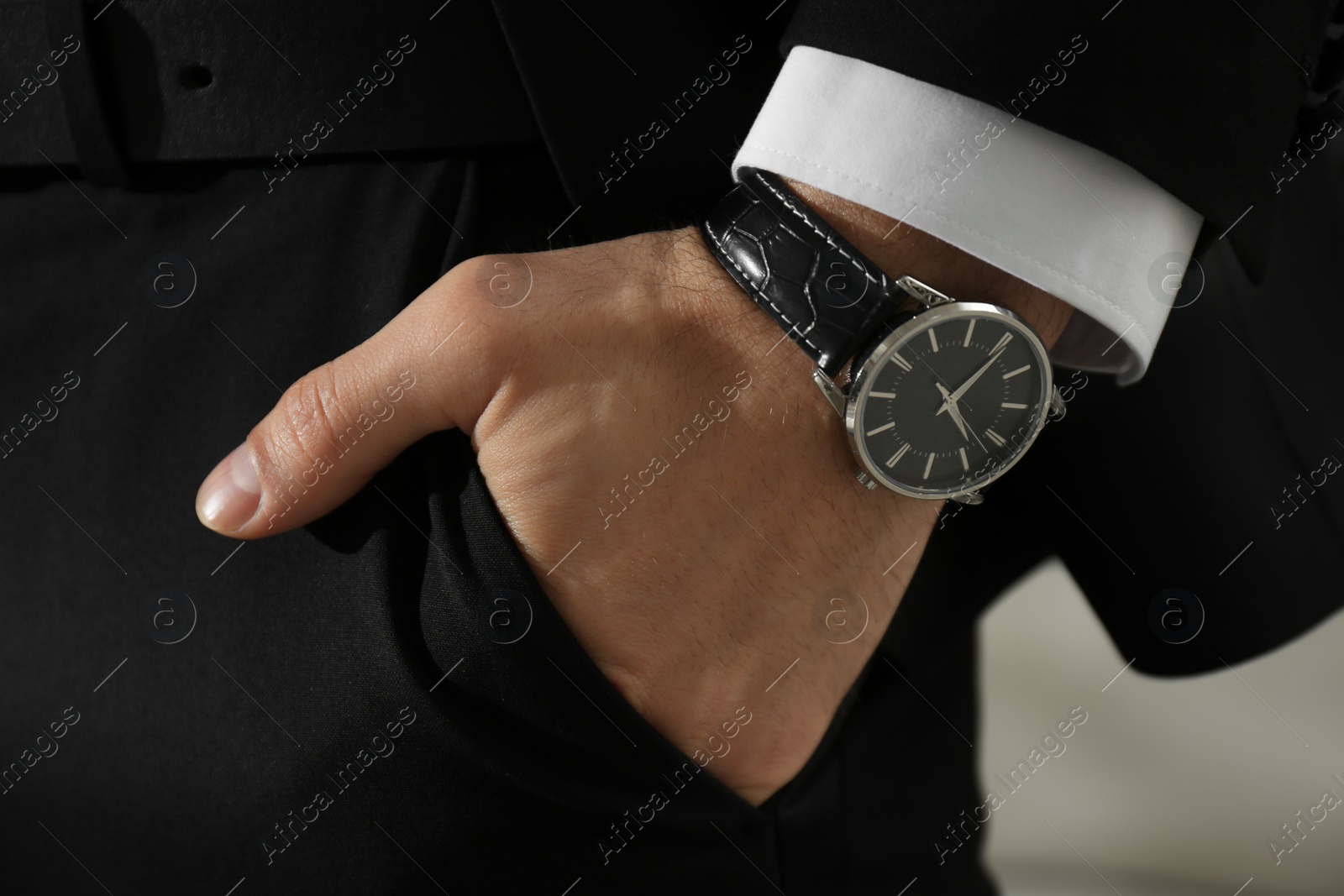 Photo of Businessman with luxury wrist watch on blurred background, closeup