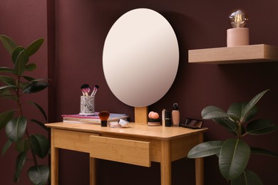 Photo of Wooden dressing table near brown wall in room