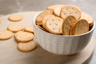 Delicious crispy crackers on wooden board, closeup