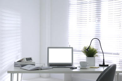 Photo of Modern laptop on office table. Stylish workplace