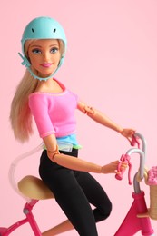 Mykolaiv, Ukraine - September 2, 2023: Beautiful Barbie doll with bicycle on pink background