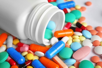 Bottle and many colorful pills, closeup