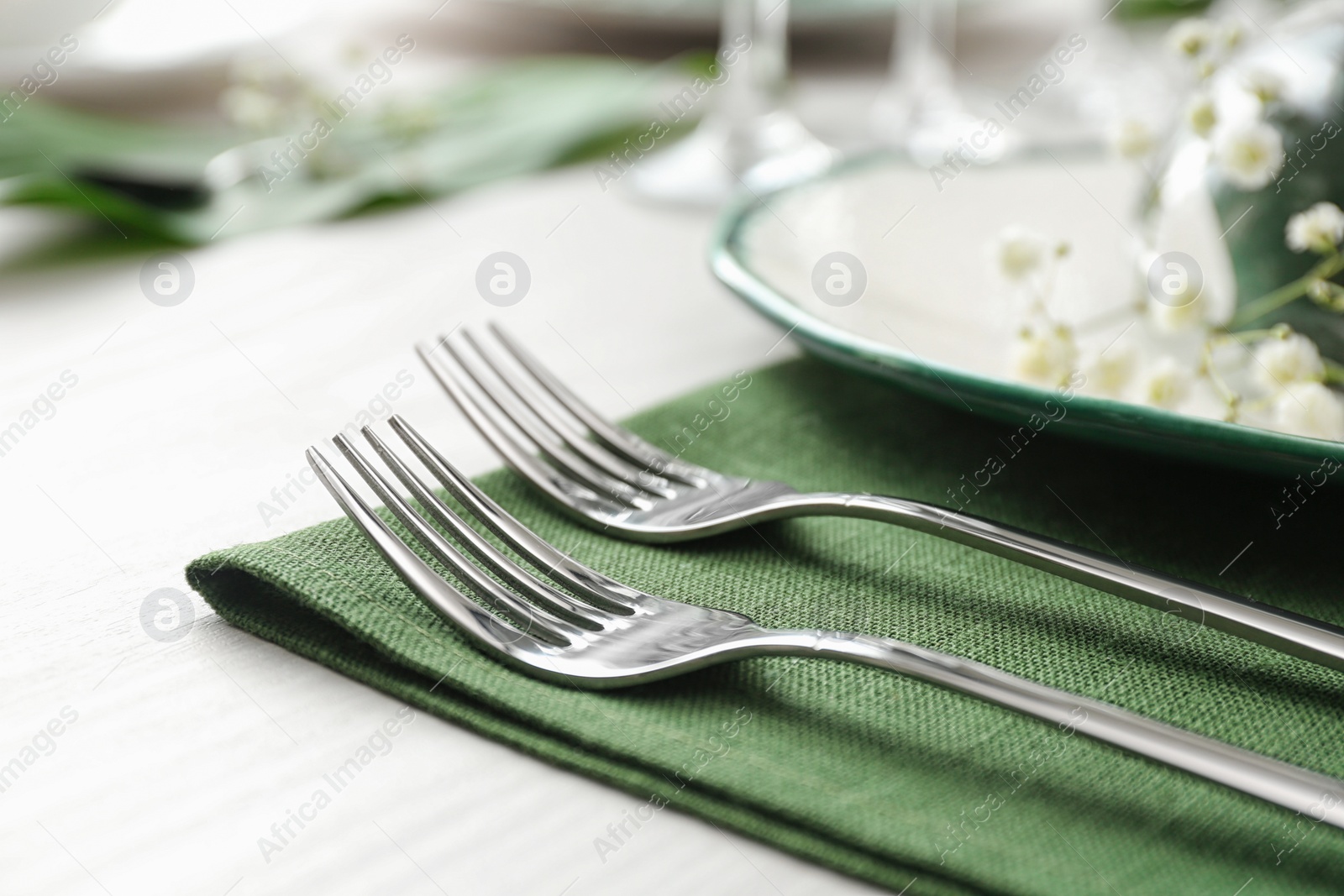 Photo of Stylish clean forks on white table, closeup. Festive setting
