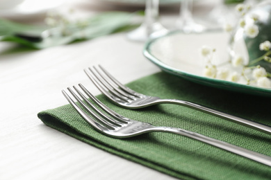 Photo of Stylish clean forks on white table, closeup. Festive setting