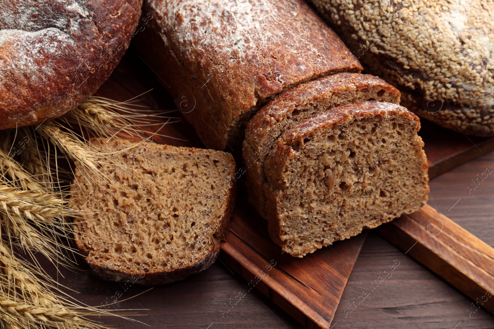 Photo of Tasty freshly baked bread on wooden table, closeup