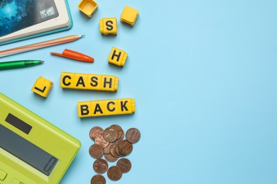 Photo of Word Cashback made with cubes, coins and calculator on light blue background, flat lay. Space for text