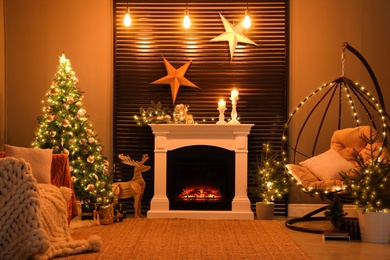 Beautiful living room interior with burning fireplace and hanging chair. Christmas celebration
