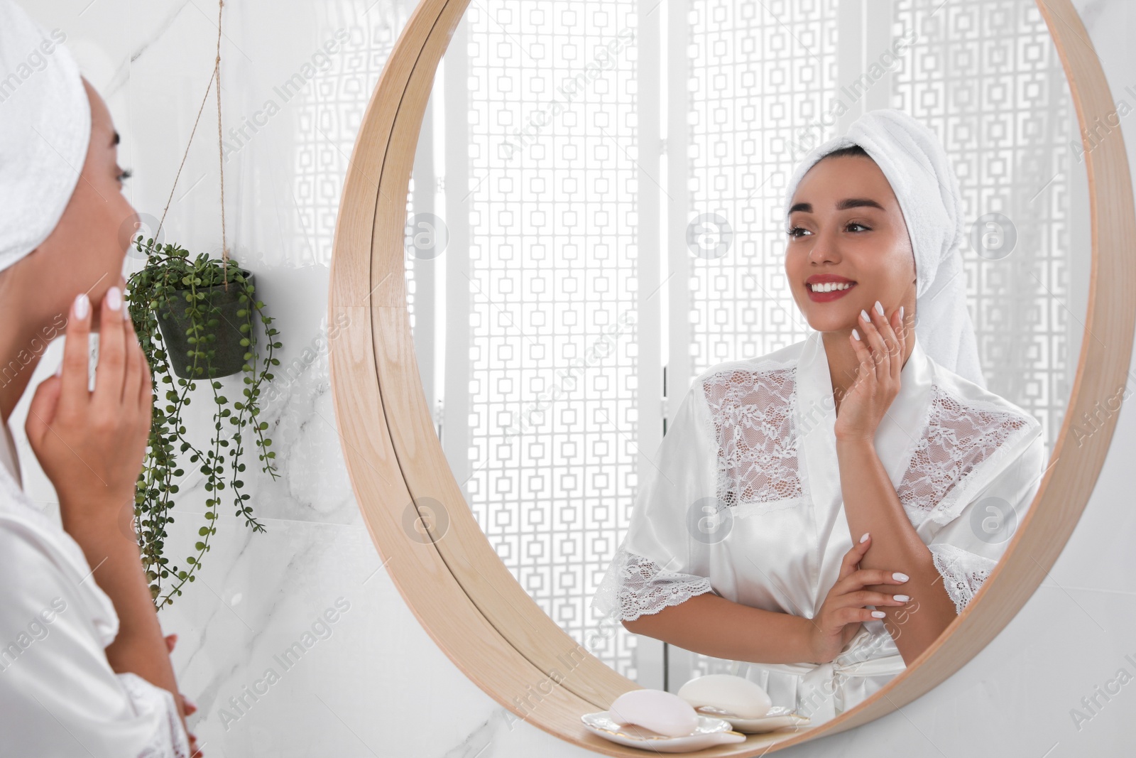 Photo of Beautiful young woman with perfect skin near mirror in bathroom. Facial wash