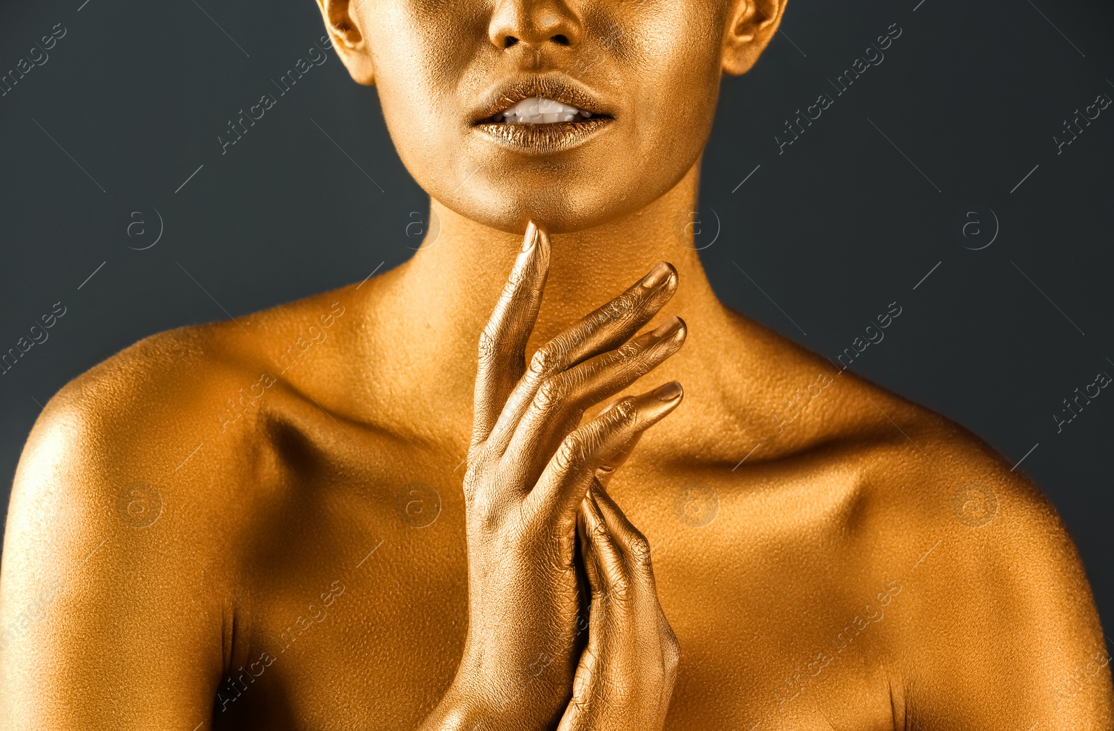Photo of Beautiful lady with gold paint on skin against grey background, closeup