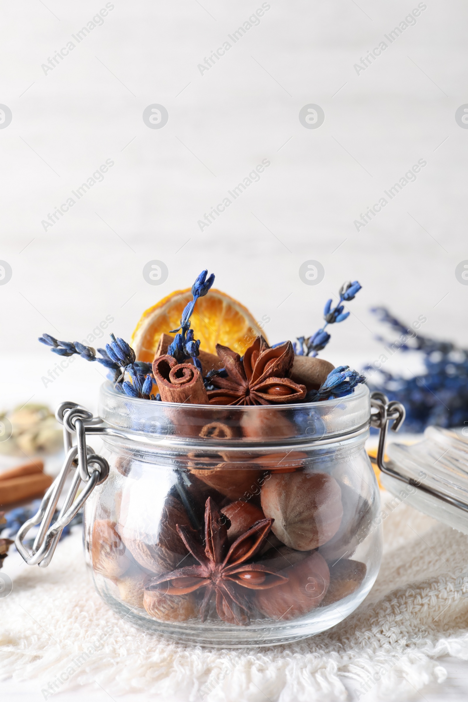 Photo of Aromatic potpourri in glass jar on white background