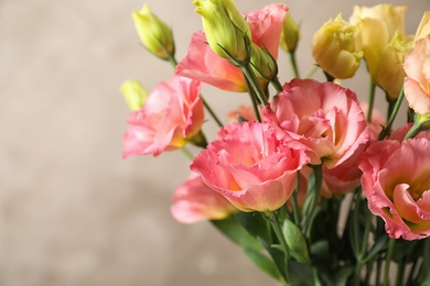 Photo of Beautiful Eustoma flowers against beige background, closeup