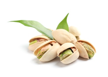 Photo of Tasty organic pistachio nuts and leaves on white background, closeup