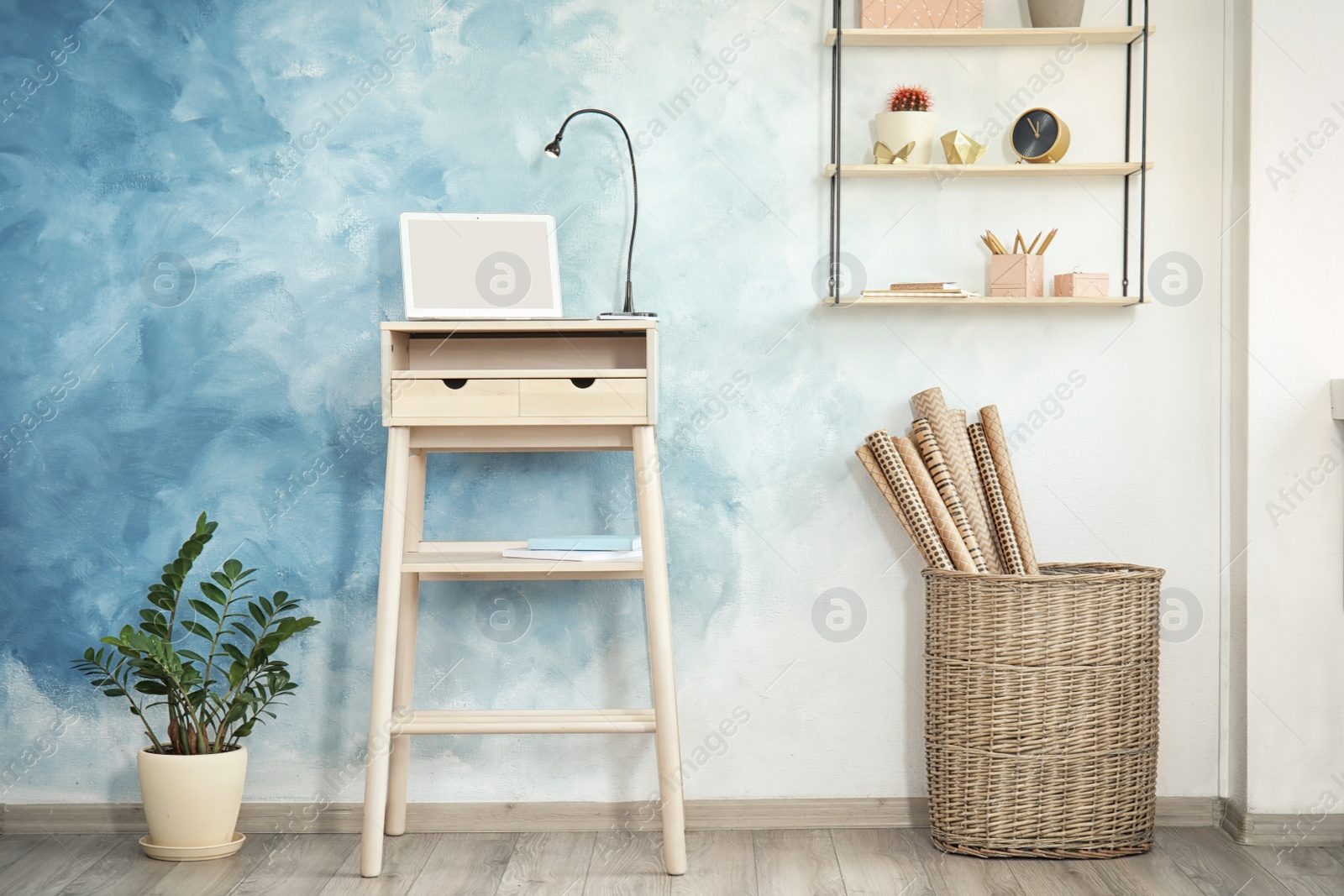 Photo of High wooden table with laptop as stand up workplace in modern interior