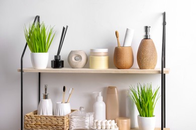Photo of Different bath accessories, personal care products and artificial plants indoors