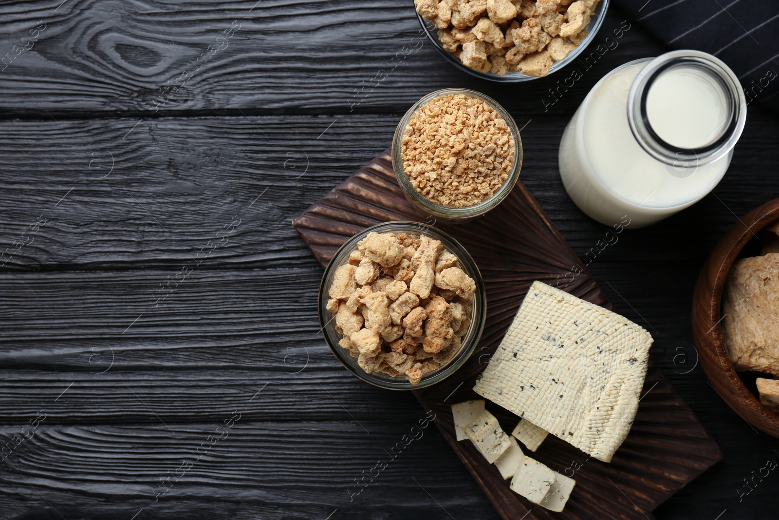 Photo of Different natural soy products on black wooden table, flat lay. Space for text